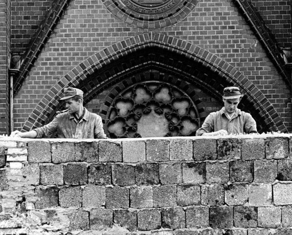 Workers trying to make the wall jump free by embedding broken glasses.