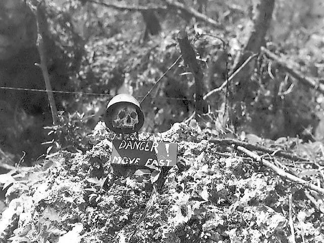 a Japanese soldier’s severed head hangs from a tree in Burma circa 1945,